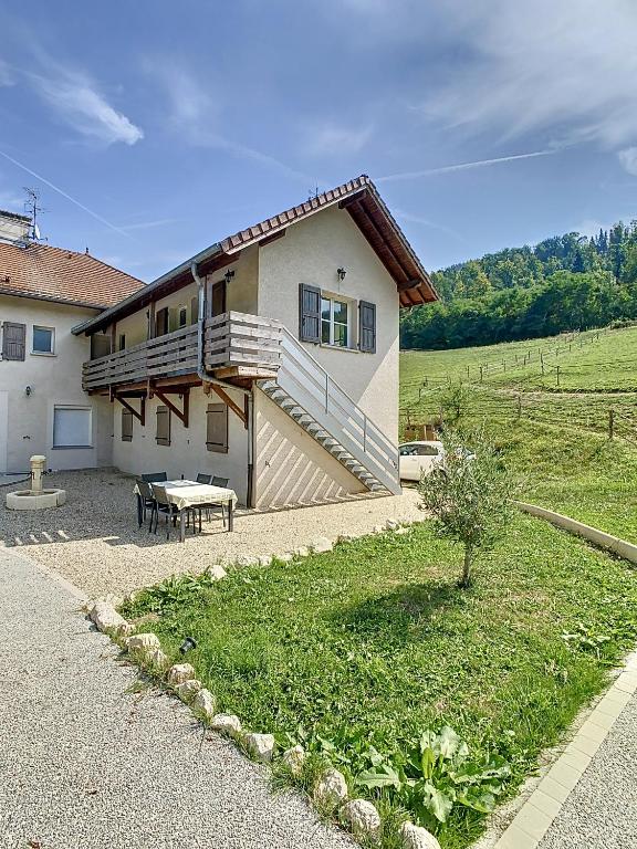 une maison avec une table de pique-nique devant elle dans l'établissement La Grimaudière, calme, campagne, animaux acceptés, à Saint-Étienne-de-Crossey