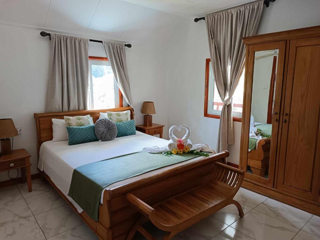 a bedroom with a large bed and a mirror at Lucy's guesthouse in La Digue