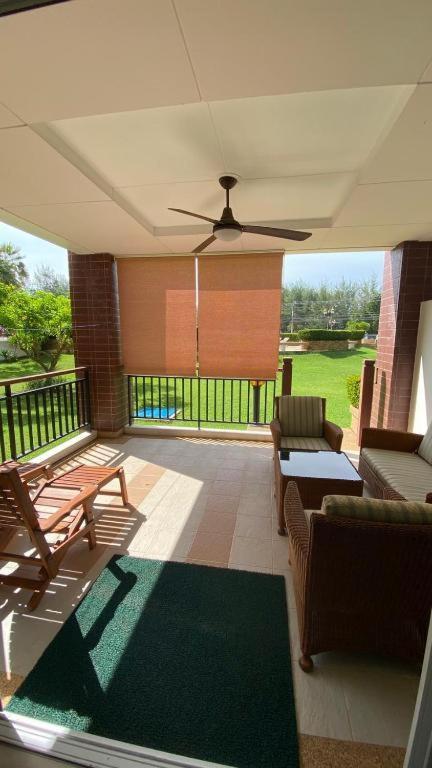 a screened in porch with a ceiling fan and furniture at Seaview Condominium A13 in Ban Tha Fat
