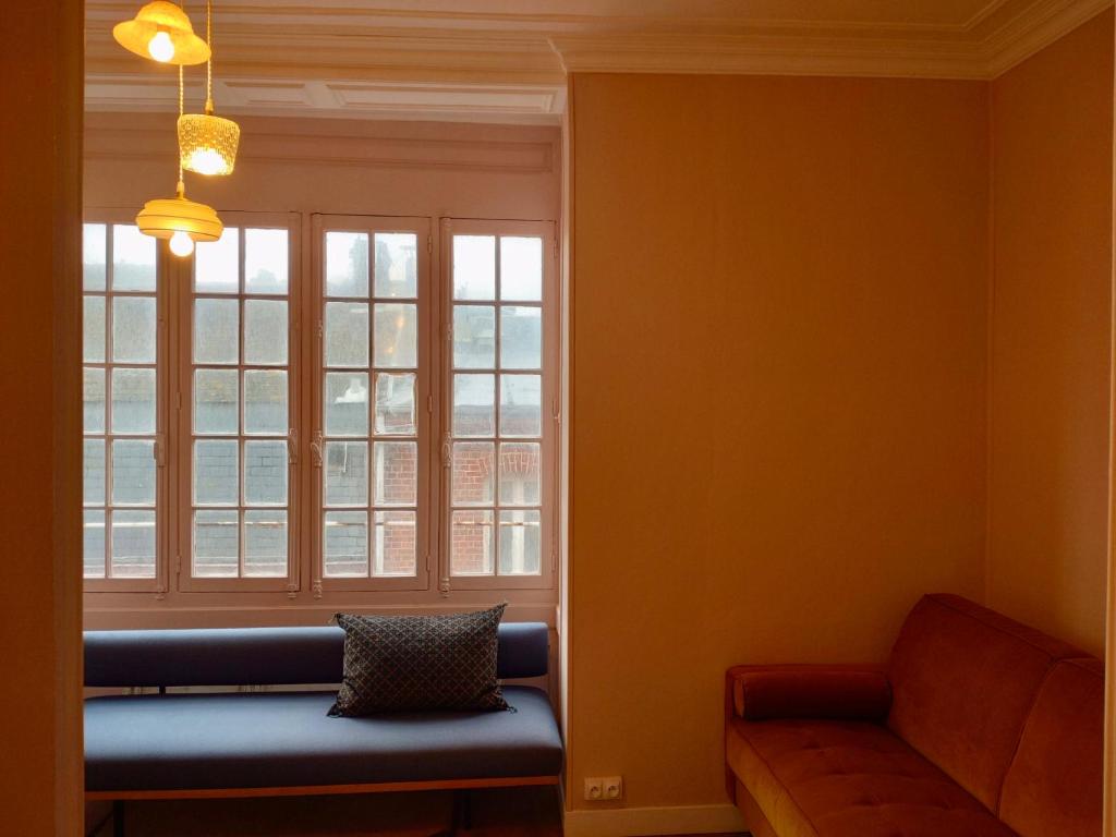 un salon avec un canapé bleu et une fenêtre dans l'établissement Appartement Le Tréport, au Tréport