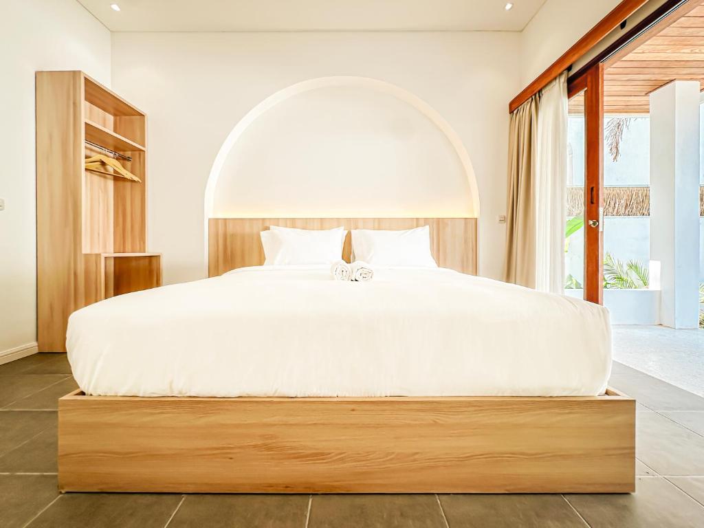 a bedroom with a large white bed with a large window at Private Pool Villa Retreat NAMU new one-bedroom 6unit in Kuta Lombok