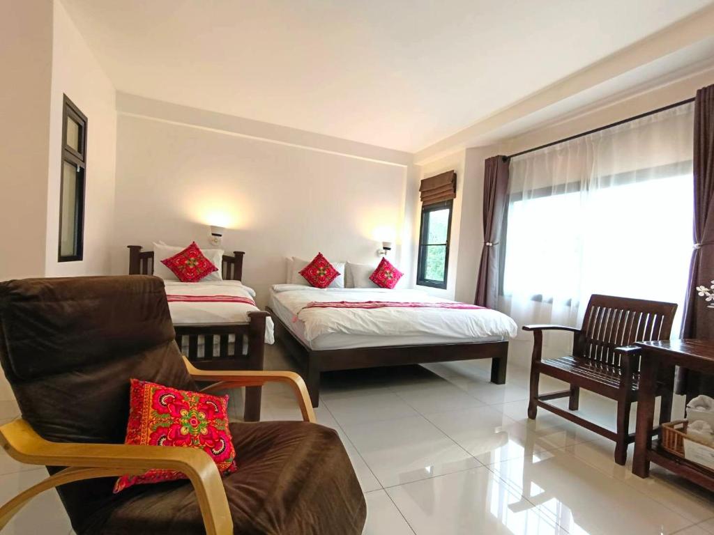 una camera con due letti, una sedia e un divano di SASIMA Bed and Breakfast a Chiang Mai