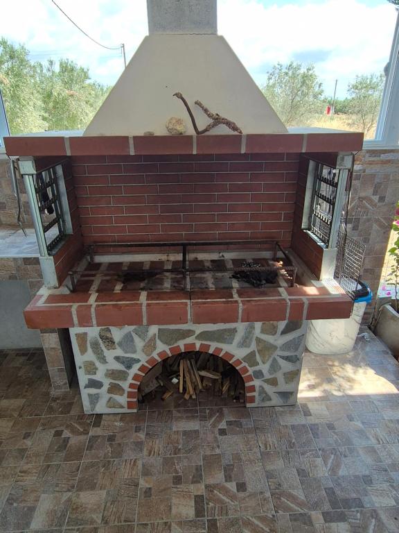 a brick fireplace with a stove in a yard at Villa Nikos in Nea Plagia