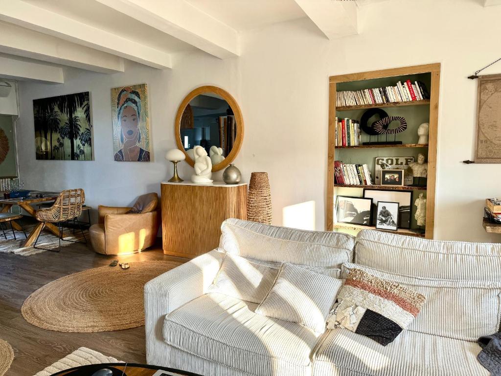 a living room with a couch and a mirror at Superbe appartement terrasse Sorgues - Avignon in Sorgues