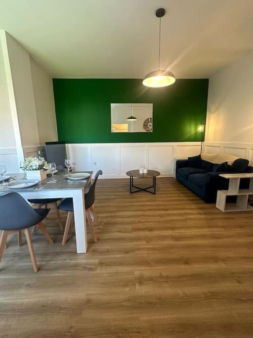 ブラックプールにあるNew Luxury apartment, sea viewWith parkingの緑の壁のリビングルーム(テーブル付)