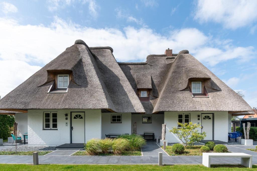 a thatched house with a thatched roof at Beach Lodge Beach Lodge Appartement 2 in Böhl