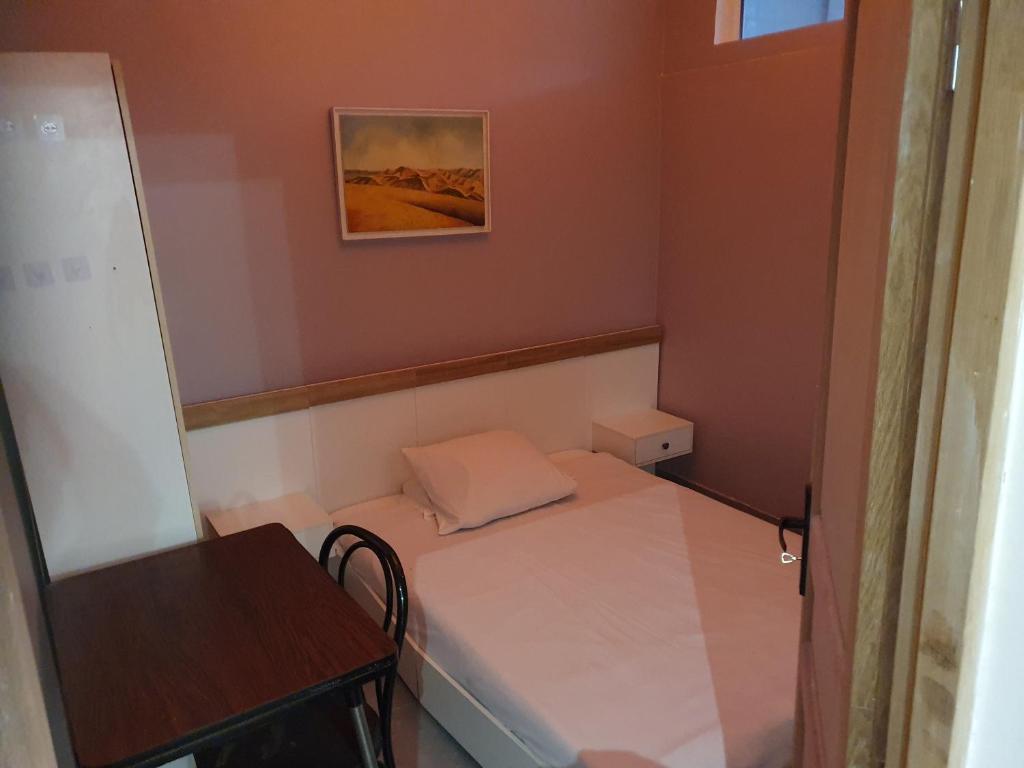 Cette petite chambre comprend un petit lit et une table. dans l'établissement confort appartement, à Conflans-Sainte-Honorine