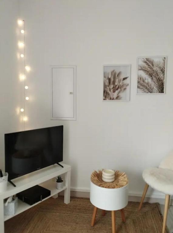 un salon avec une télévision et une table dans l'établissement Chambre d'amour, à Villeneuve-lès-Avignon