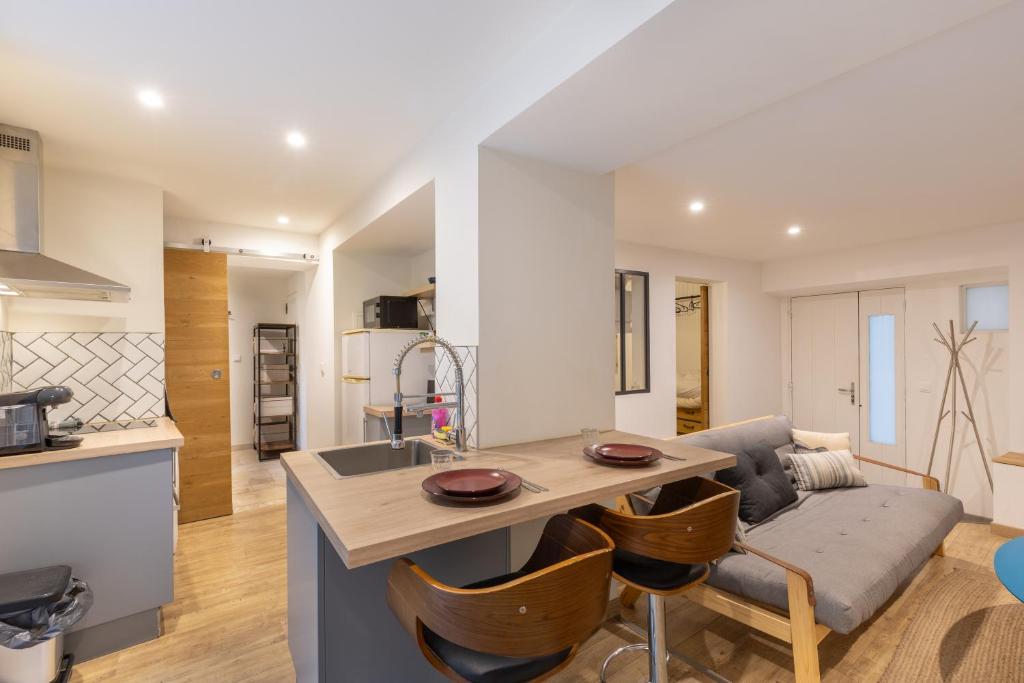 une cuisine et un salon avec une table et un canapé dans l'établissement Le Reflet du Rhône - Intramuros - Wifi - Clim, à Avignon