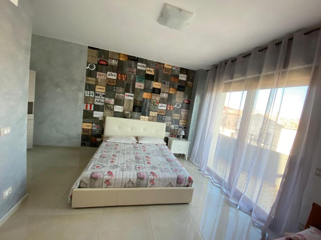 a bedroom with a bed and a wall of pictures at La dimora dei Sanniti in Busso