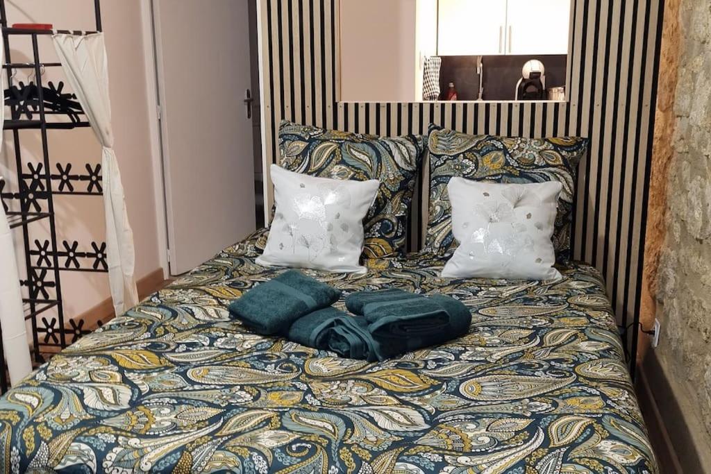 a bed with green sheets and pillows on it at Cosy Bellamy in Angoulême