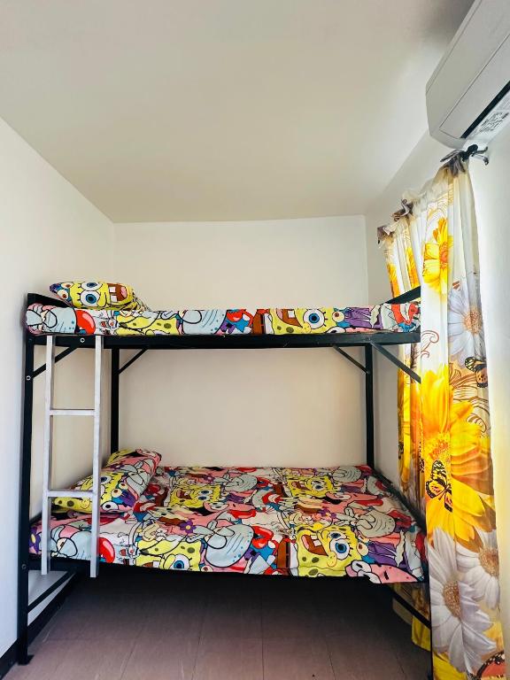 a bedroom with two bunk beds with colorful sheets at 2 StoryHome in Tanza near SM along Main Road in Tanza