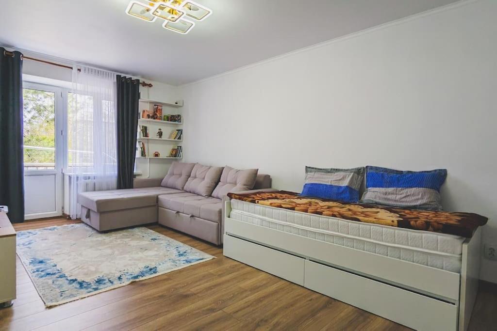 a bedroom with a large bed and a couch at Cozy apartment in the city center of Karakol in Karakol