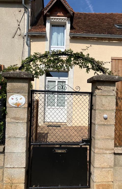 un bâtiment avec une porte noire et une fenêtre dans l'établissement La Sauveroise, à Saint-Sauveur-en-Puisaye