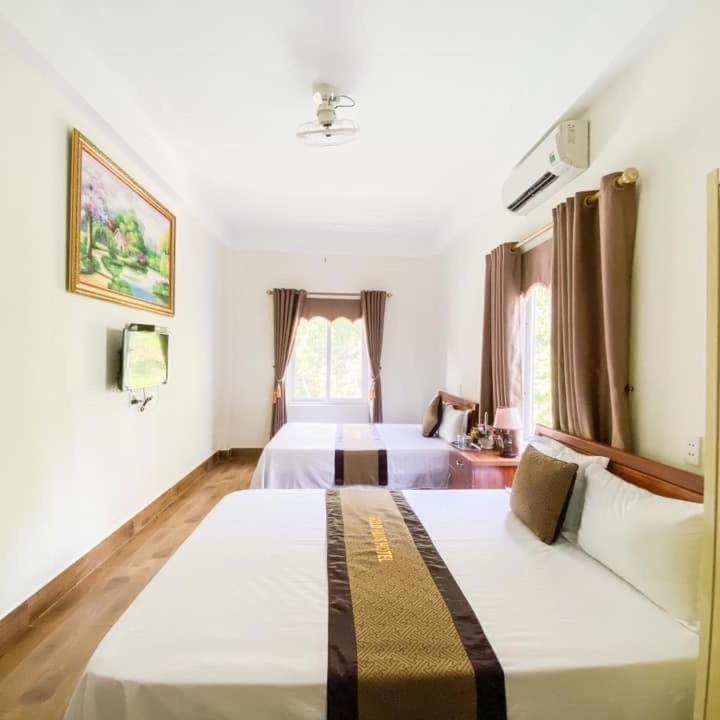 a bedroom with two beds and a window at Gold Plus hotel in Phong Nha