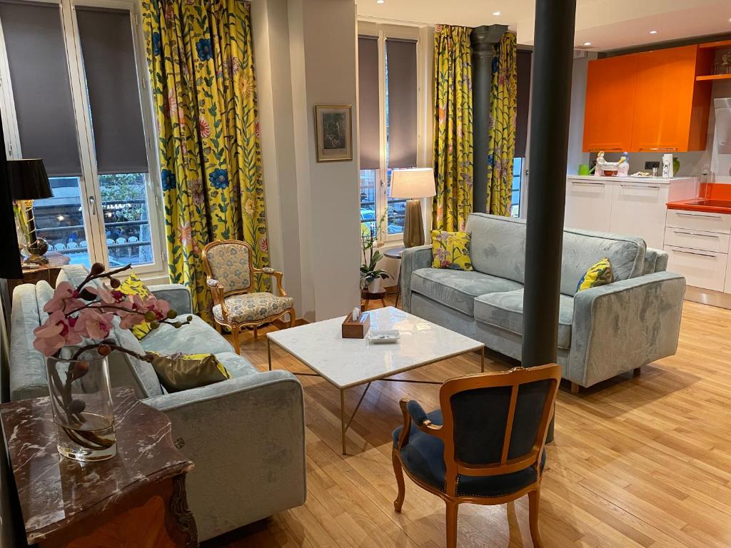 un salon avec un canapé et une table dans l'établissement Appartement familial au coeur de Paris, à Paris