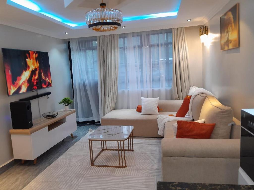 a living room with a couch and a tv at Weber Generations Accommodation -R & R Cozy Homes in Naivasha