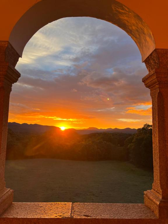 a view of a sunset through an archway at Casa Rural El Callís in Vall de Bianya