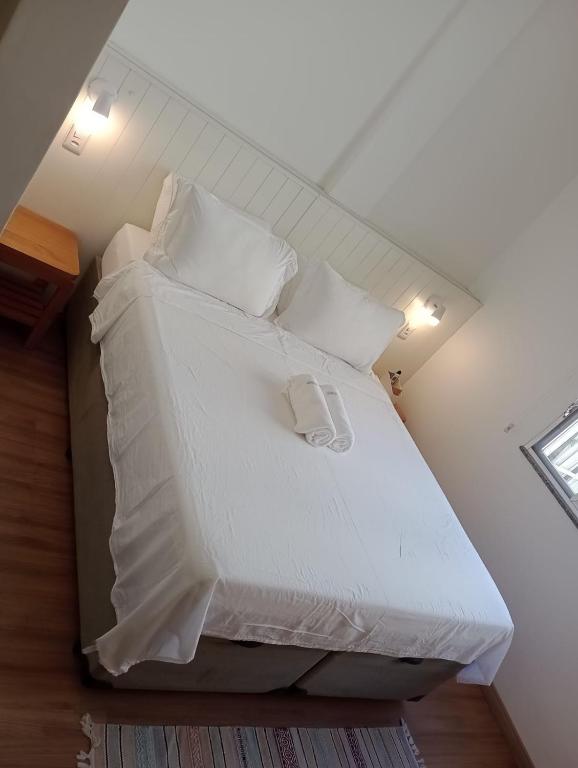 Un dormitorio con una cama con sábanas y almohadas blancas. en Ipanema prudente 211, en Río de Janeiro