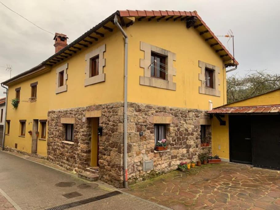 a yellow building with windows on a street at La Casuca de Coo in Coó