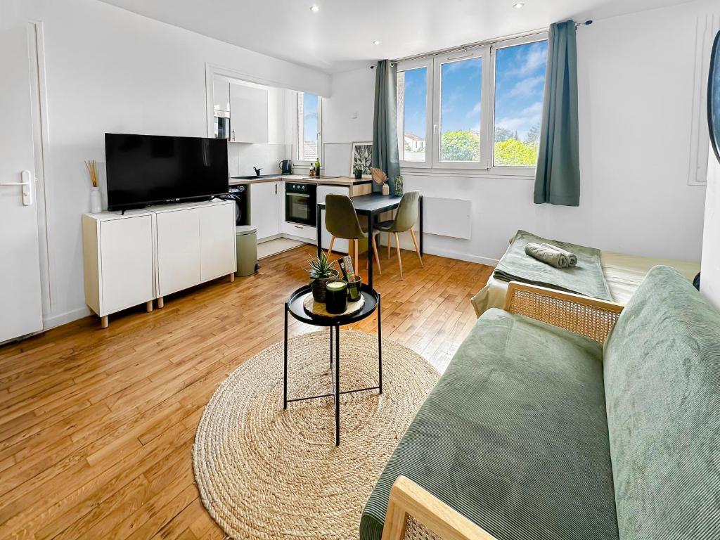 un salon avec un canapé et une table dans l'établissement Arrêt Paisible à Maisons Alfort, à Maisons-Alfort