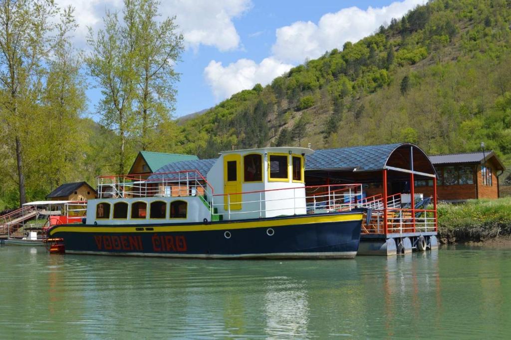 a yellow and blue boat sitting in the water at Kamp Vodeni Ćiro in Setihovo