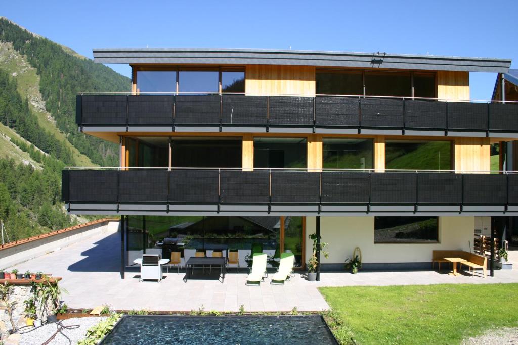 a house with a balcony with chairs and a patio at Rumwaldhof - Wohnung Enzian in Solda