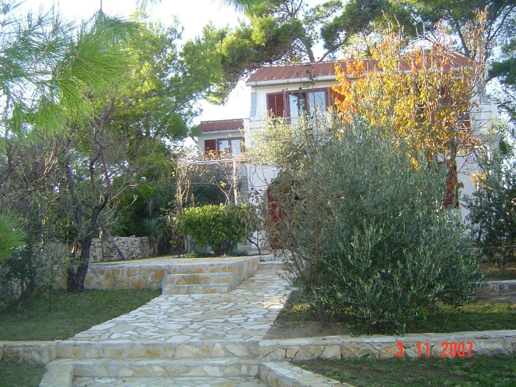 a house with a stone path in front of it at Apartments Jakišnica in Jakišnica