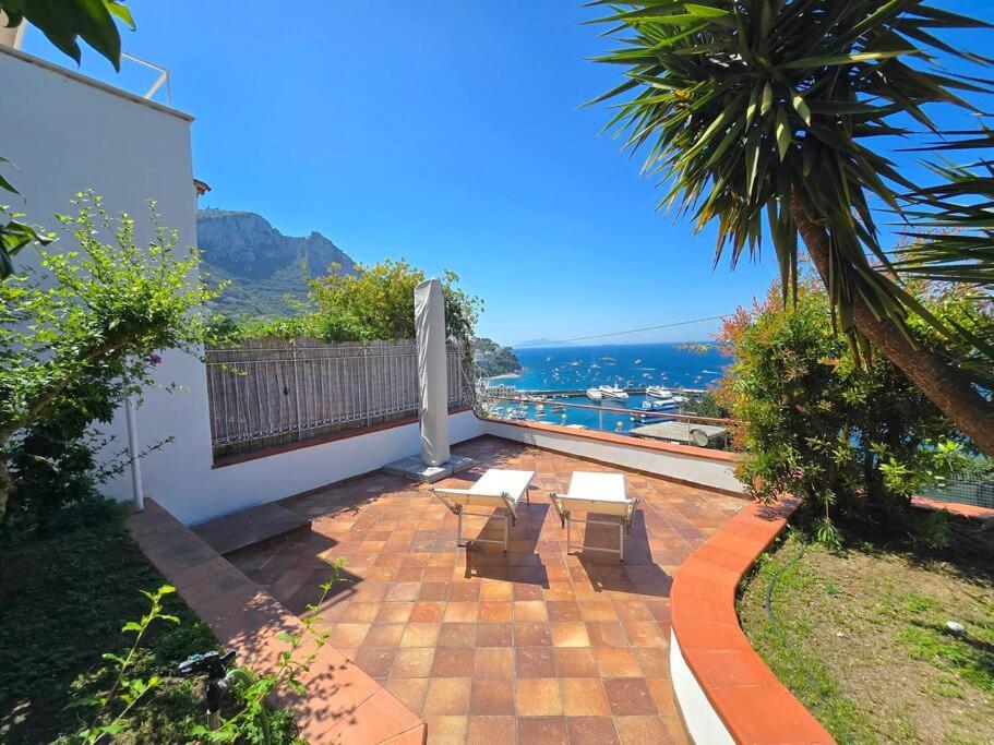 Un patio con bancos y vista al mar. en Casa Gentile, en Marina Grande