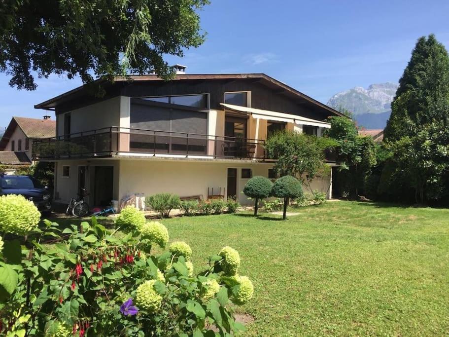 une maison avec une grande cour avec de l'herbe verte dans l'établissement La Maison des Pêcheurs, au pied du lac, à Saint-Jorioz