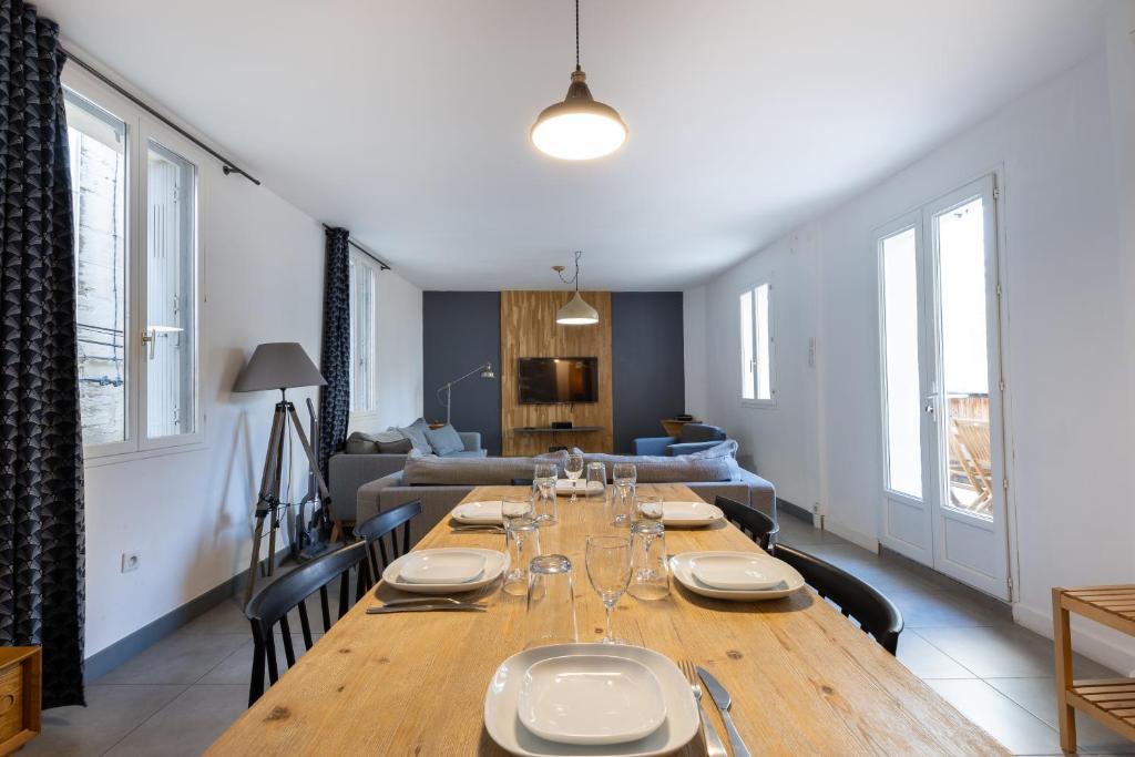 - un salon avec une grande table en bois et un canapé dans l'établissement Le Pont d'Avignon - Maison de ville - 4 chambres - Intramuros, à Avignon