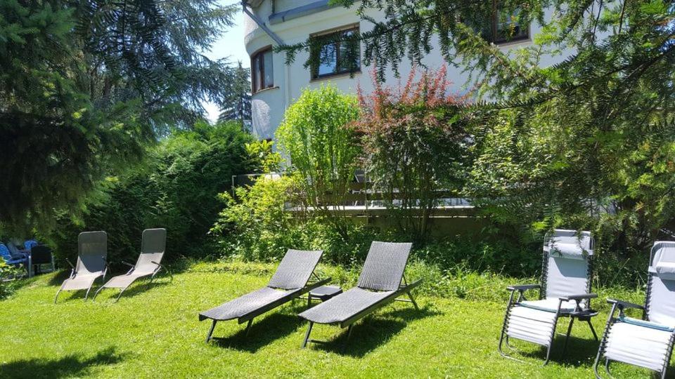 a group of lawn chairs sitting in the grass at Schönes Ferienhaus mit Garten in Friedrichshafen am Bodensee in Friedrichshafen