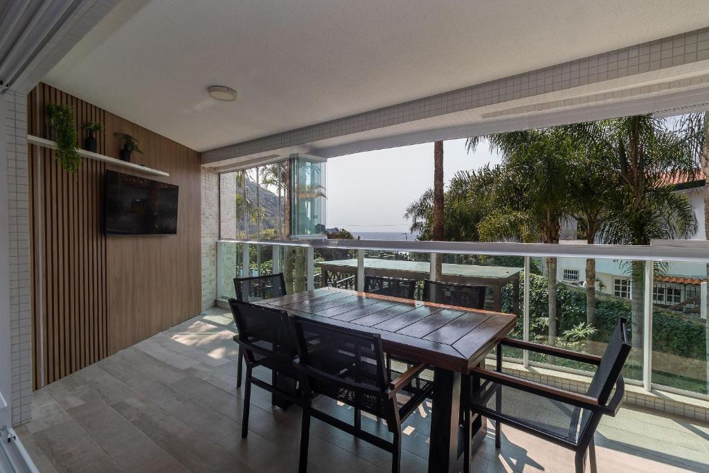 a dining room with a table and chairs on a balcony at Varandas do Atlântico 101A - Excelente apartamento em condomínio de luxo a beira mar - Piscina climatizada - Academia - (Consultar serviços de roupas de cama e banho) in Bombinhas
