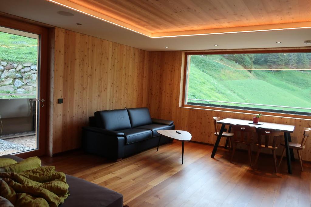 a living room with a leather couch and a table at Rumwaldhof - Wohnung Arnika in Solda