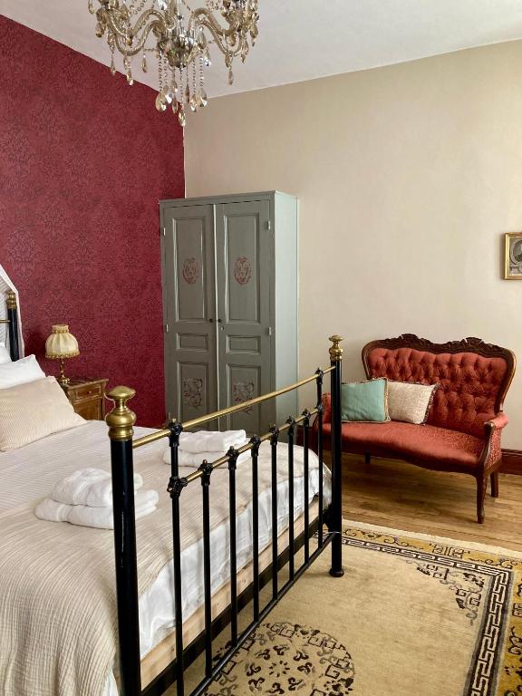 - une chambre avec un lit, une chaise et un lustre dans l'établissement Chateau Gioux, à Saint-Pierre-Bellevue