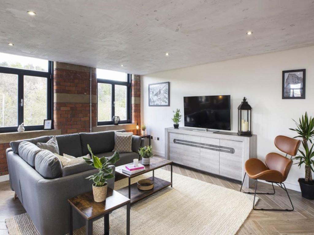 a living room with a couch and a flat screen tv at 5-Bedroom Luxury Duplex Penthouse in Bradford