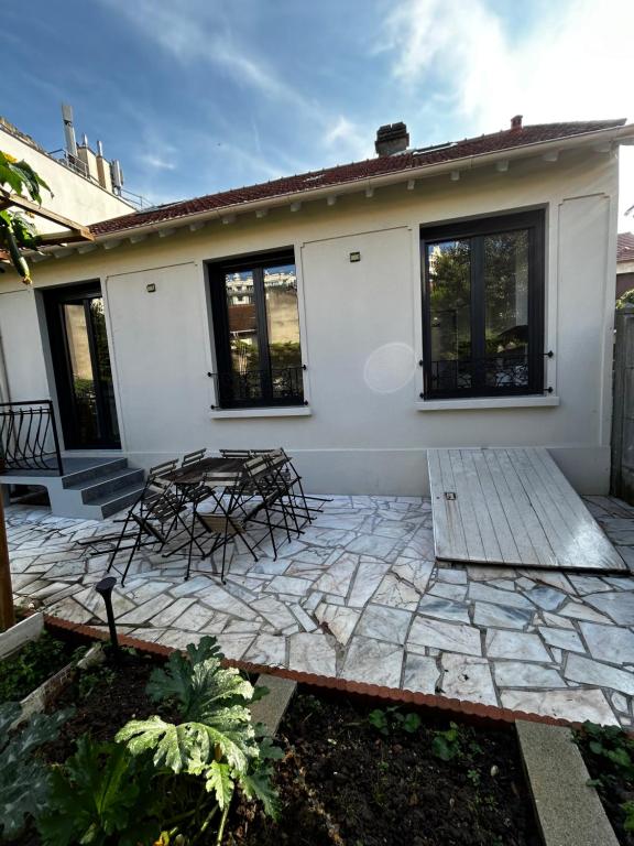 a patio with two chairs and a house at Maison Cosy, Grand Paris, à 3 minutes du métro in Villejuif