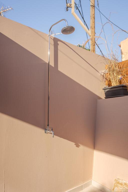 a shower on the side of a wall with a plant at Comfinest in Chania