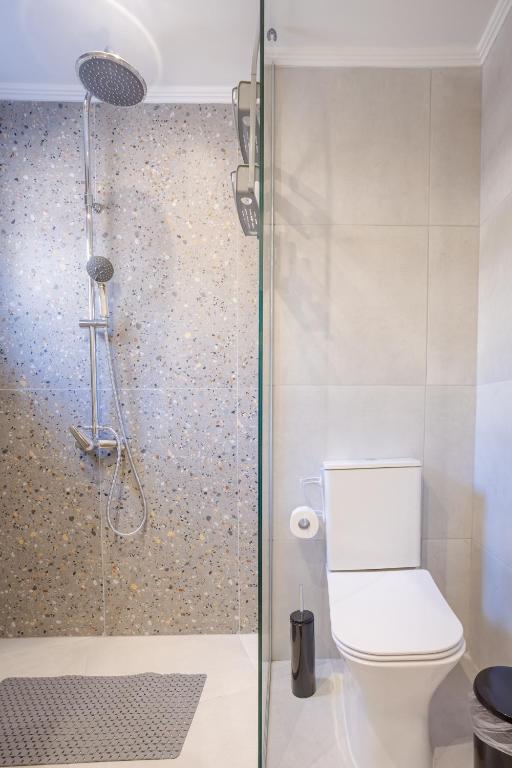 a bathroom with a toilet and a glass shower at Comfinest in Chania