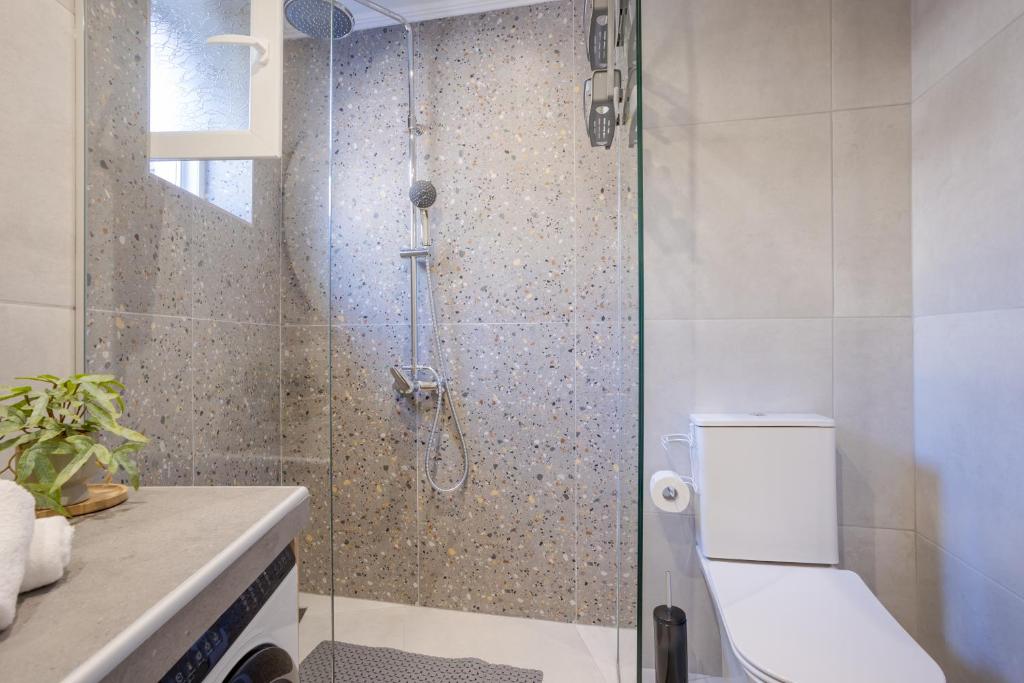 a bathroom with a glass shower with a toilet at Comfinest in Chania