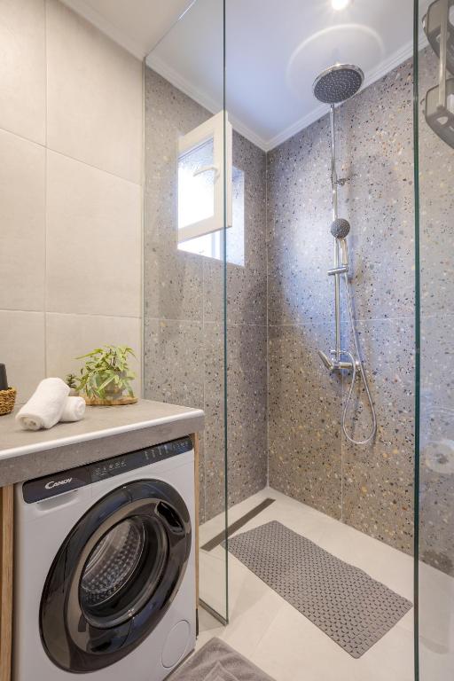 a washing machine in a bathroom with a shower at Comfinest in Chania