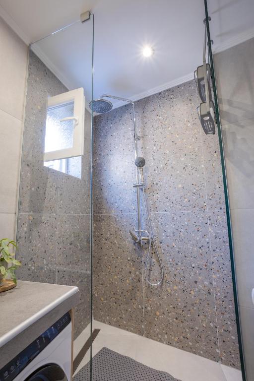 a shower with a glass door in a bathroom at Comfinest in Chania