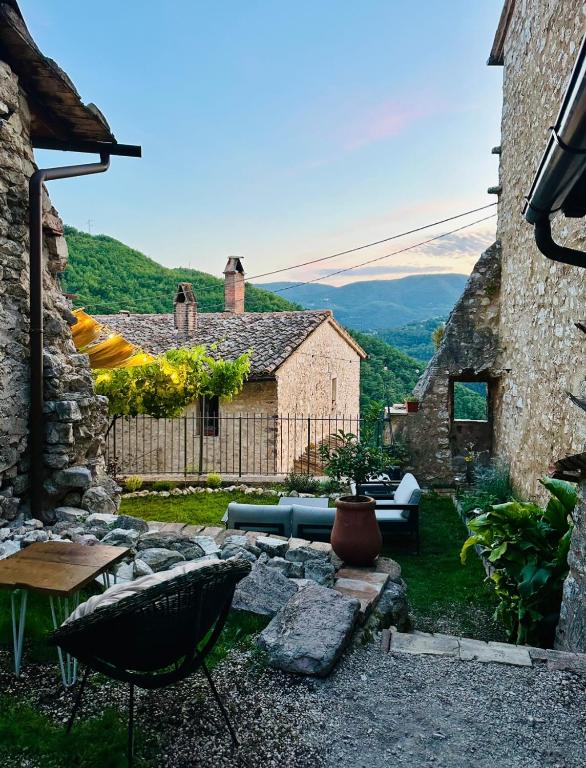 a patio with a couch and a table in a yard at Maison Le Calle in Vallo di Nera
