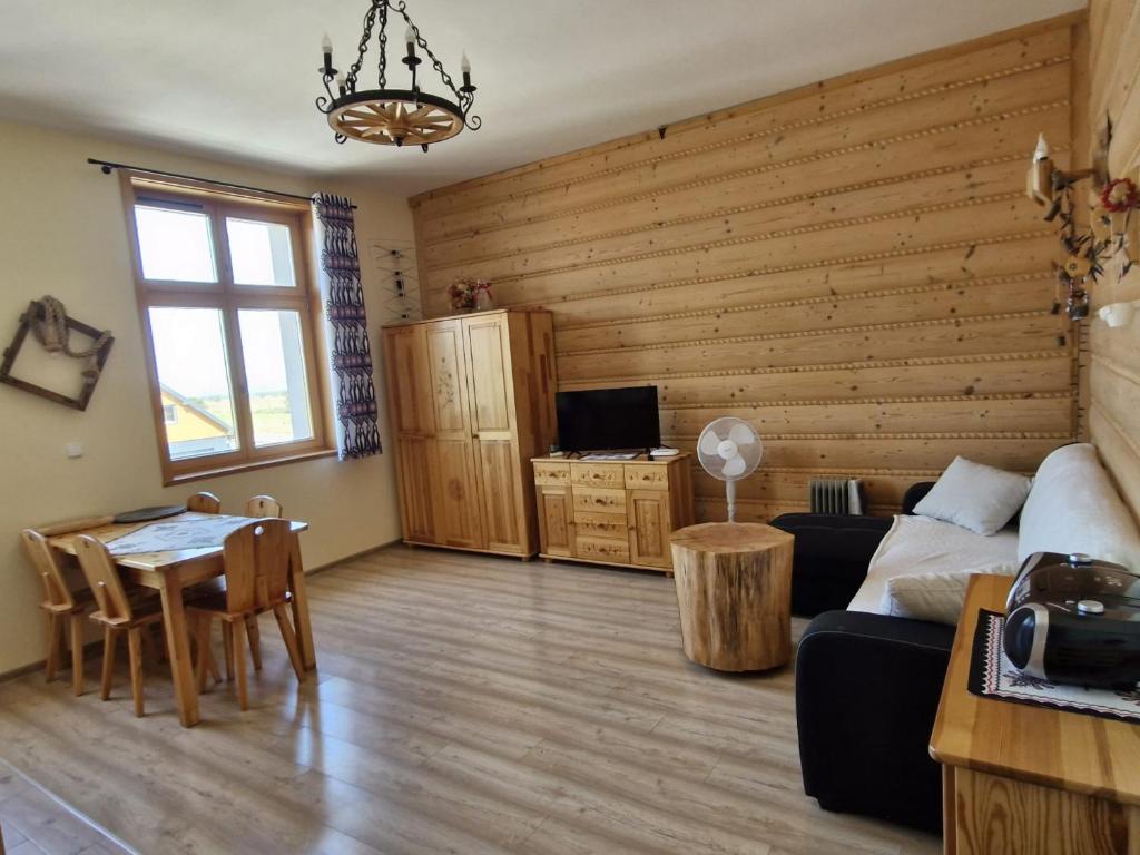 a living room with a couch and a table at Apartamenty na Szlaku in Czarny Dunajec
