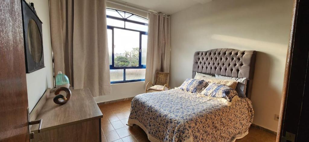 a bedroom with a bed and a window at Casa Villa Fortunato Barreiro in Araxá