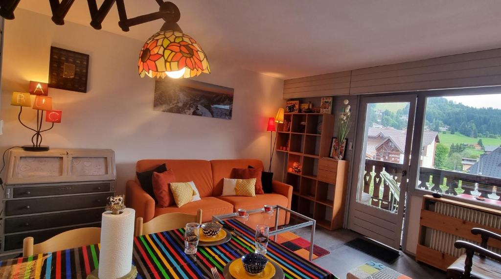 un salon avec un canapé et un balcon dans l'établissement Vintage chic -central, wifi, mountain view, aux Carroz d'Arâches