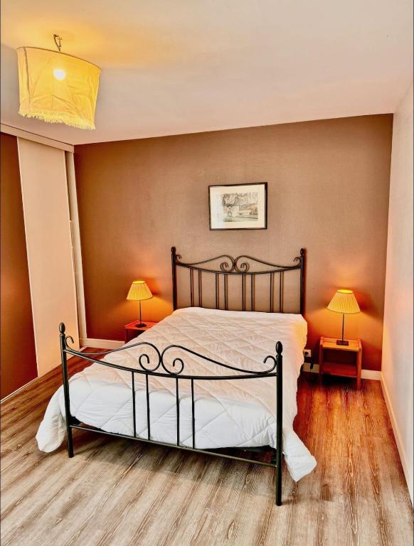 - une chambre avec un lit et deux lampes sur les tables dans l'établissement Maison au château de Laléard, à Saint-Hilaire-de-Villefranche