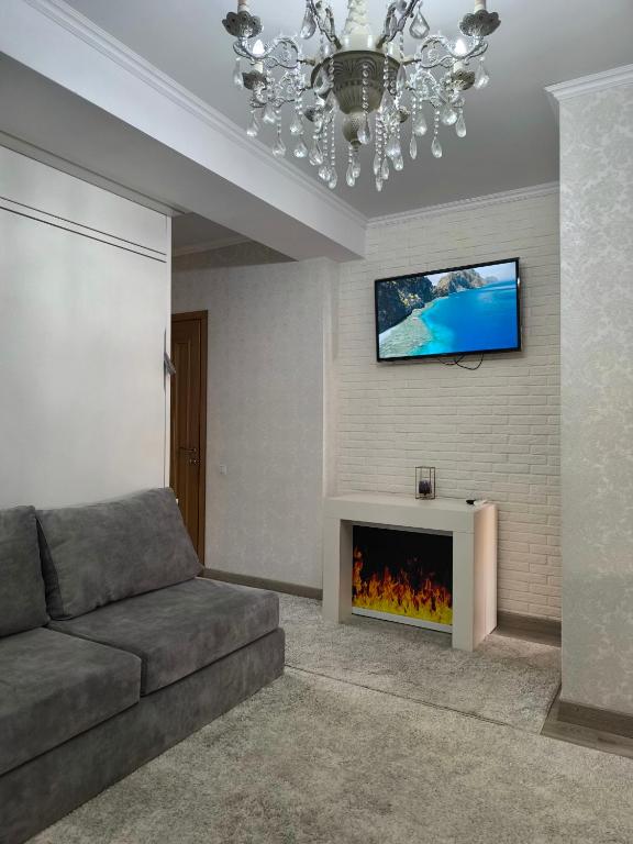 a living room with a couch and a fireplace at Apart Lux Melestiu in Chişinău