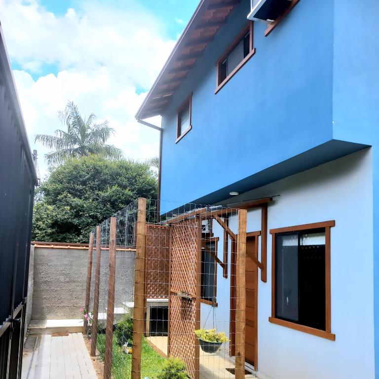 a house with a blue roof at Encanto da Serra Suítes Lumiar in Lumiar