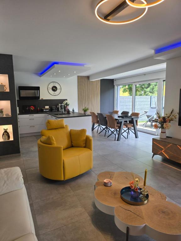 un salon avec un canapé jaune et une table dans l'établissement La Belle Etape, à Sarreguemines